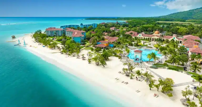 Aerial view of Sandals South Coast showcasing beachfront setting, overwater bungalows, and lush tropical landscape along Jamaica’s south coast