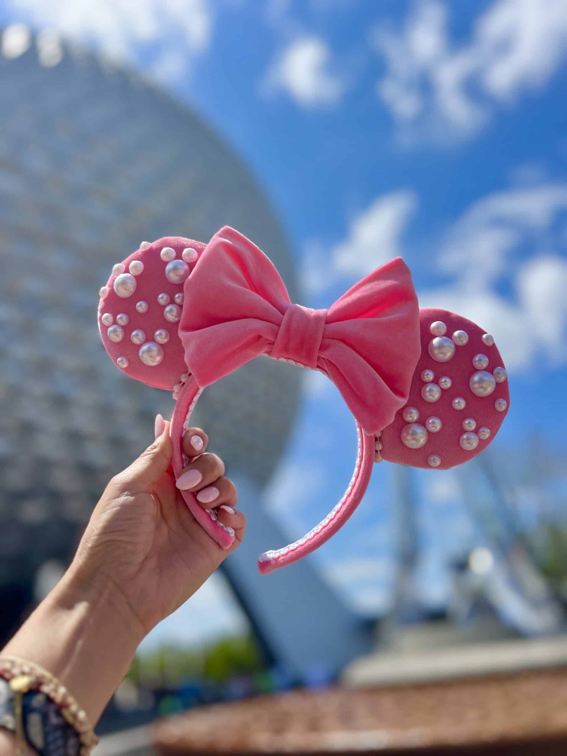Pink Minnie ears in front of Spaceship Earth at EPCOT in Walt Disney World