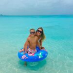 Mother and son enjoying a sunny day at Grace Bay Beach during a June 2025 family vacation at Beaches Turks and Caicos Resort. They're smiling on a colorful float in crystal-clear turquoise water.
