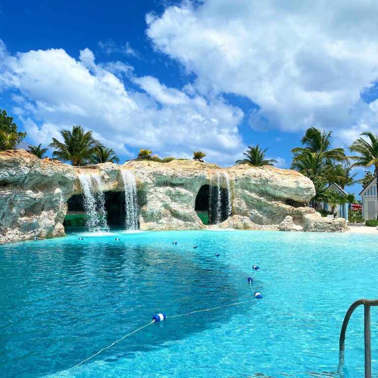 The stunning grotto pool with cascading waterfalls at Baha Mar resort in Nassau, Bahamas. Crystal-clear blue water, tropical palm trees, and bright skies create the ultimate luxury Caribbean escape.