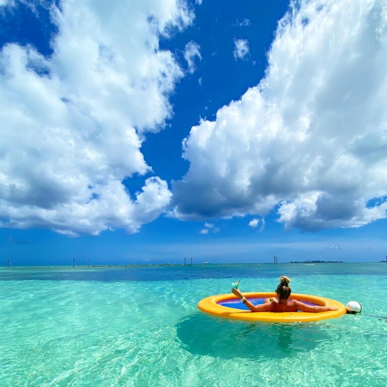 Guest relaxing on an ocean float in the crystal-clear turquoise waters at the Grand Hyatt Baha Mar resort in Nassau, Bahamas.