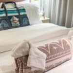 A towel animal shaped like an elephant placed on a bed inside a Disney Cruise Line stateroom.