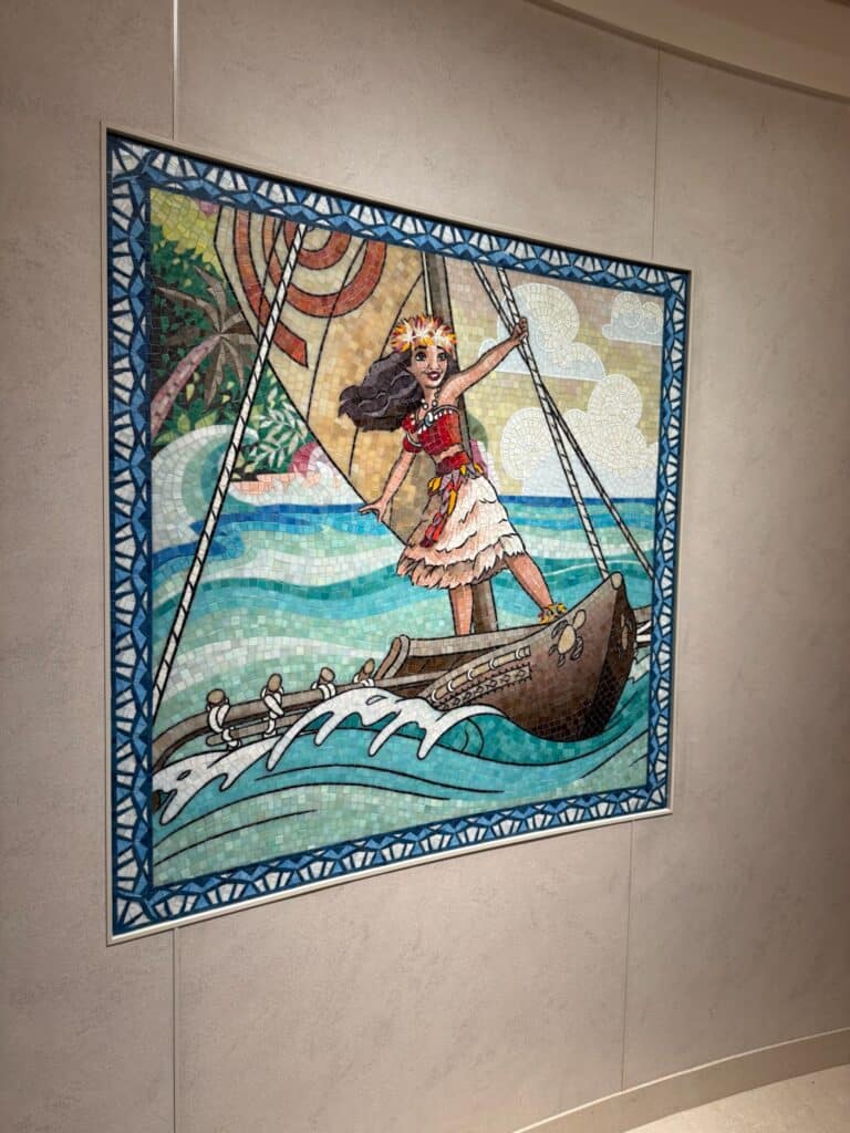 Colorful mosaic tile artwork of Moana sailing her canoe, displayed on the Disney Treasure cruise ship.
