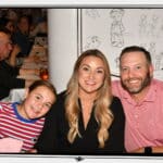Family smiling together at Animator’s Palate aboard the Disney Wonder, with Disney character sketches on the walls in the background during a Disney Alaska Cruise.