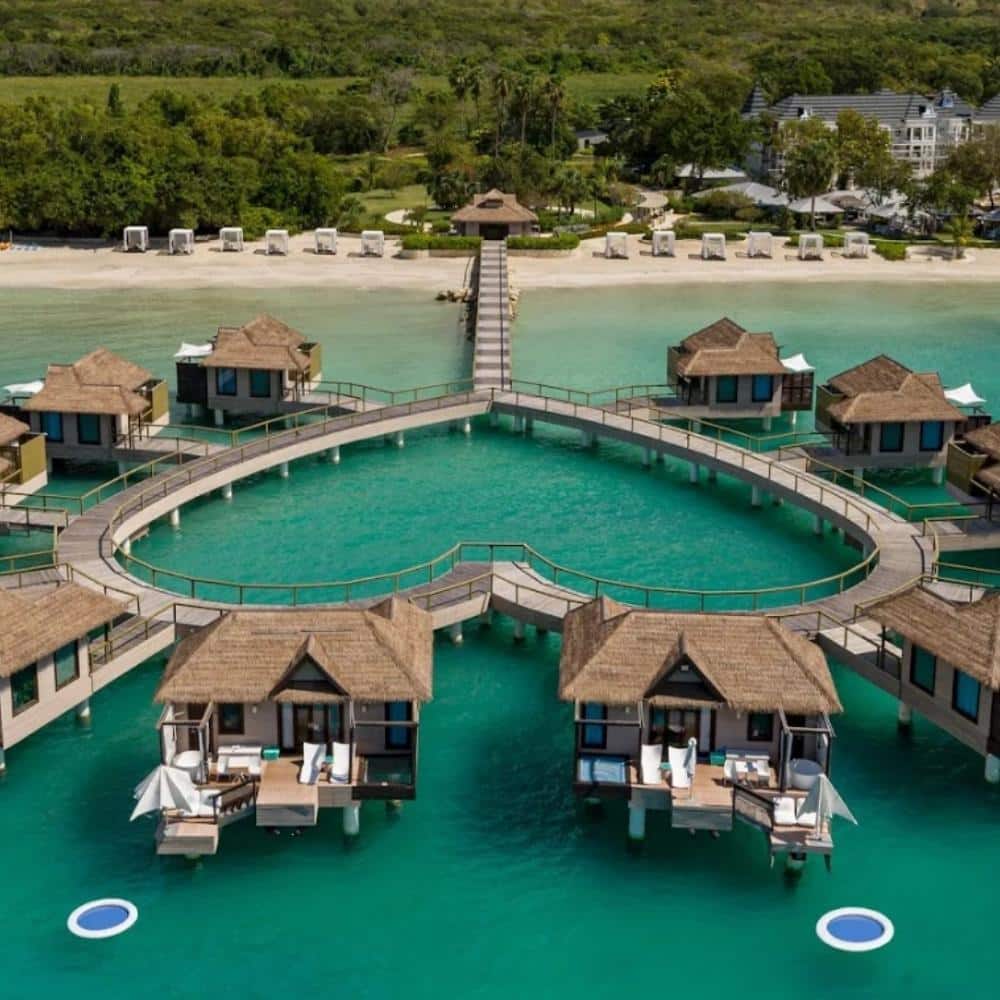 Close-up view of an overwater bungalow deck above clear blue Caribbean water.