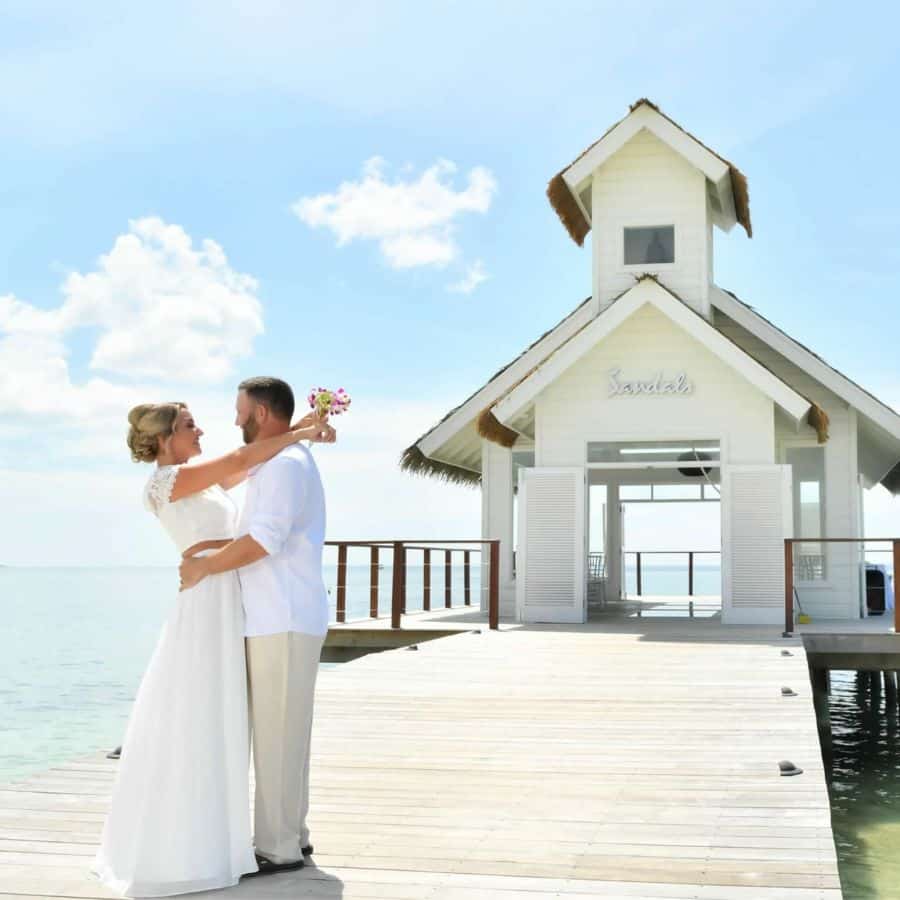 Sandals South Coast beach wedding ceremony in Jamaica with oceanfront setup and floral arch