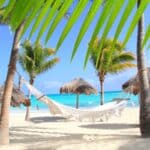 Sandals Royal Curaçao beach featuring crystal-clear turquoise Caribbean water, coral-rich shoreline, oceanfront cabanas, and a luxurious adults-only beachfront setting with stunning coastal views
