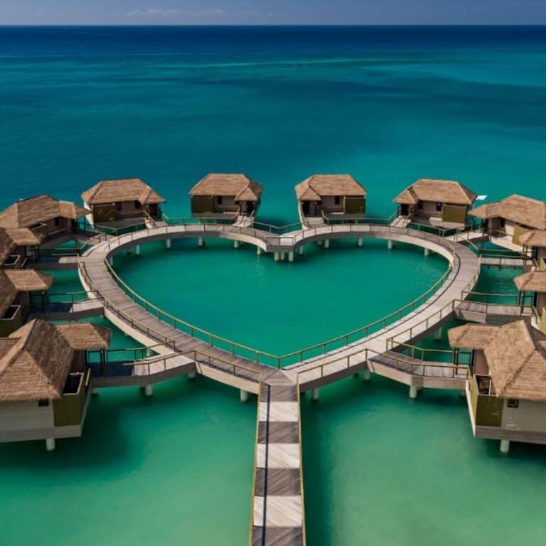 Overwater bungalows at Sandals South Coast featuring luxurious private villas above the Caribbean Sea with glass floors and direct ocean access