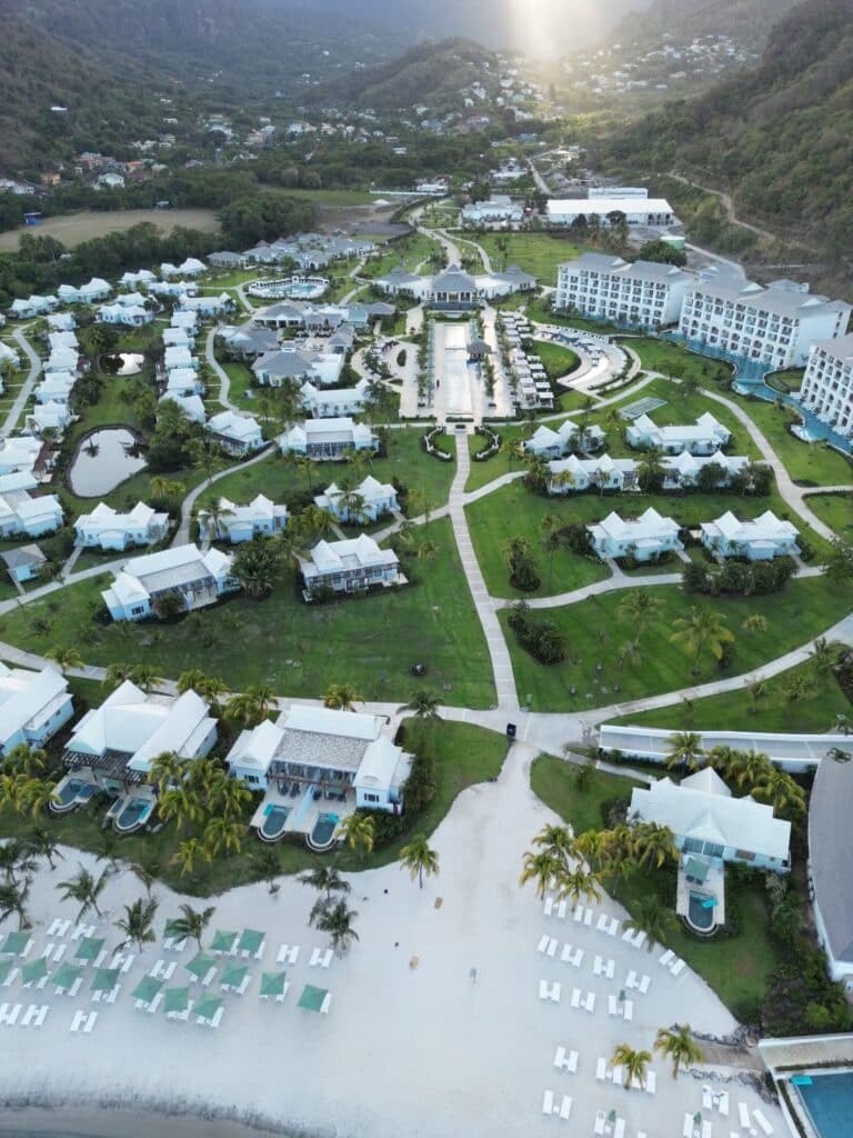 Aerial view of Sandals Saint Vincent resort with beachfront, lush mountains, and turquoise Caribbean water