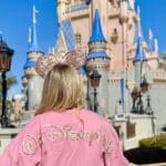Cinderella Castle at Magic Kingdom with guest wearing Minnie ears at Disney World.