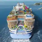 Aerial view of Icon of the Seas showcasing massive ship design, top-deck attractions, and ocean surroundings at sea