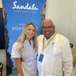 Stephanie Howard with Gary Sadler from Sandals Resorts at a Sandals property.