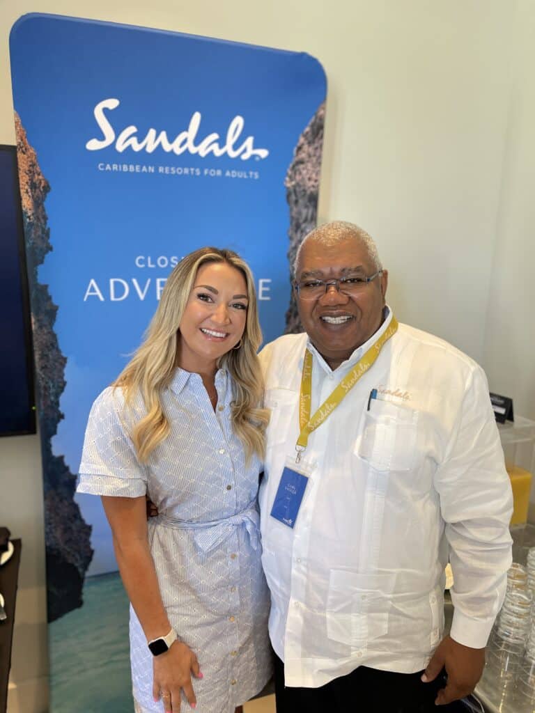 Stephanie Howard with Gary Sadler from Sandals Resorts at a Sandals property.