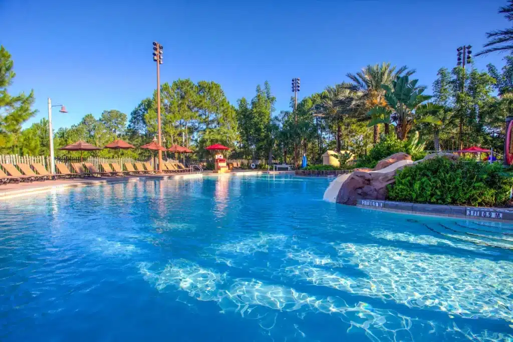 Disney’s Animal Kingdom Lodge pool area featuring a large zero-entry Uzima Springs Pool, lush tropical landscaping, sun loungers, and a relaxing resort atmosphere at Walt Disney World Resort