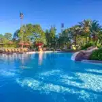 Disney’s Animal Kingdom Lodge pool area featuring a large zero-entry Uzima Springs Pool, lush tropical landscaping, sun loungers, and a relaxing resort atmosphere at Walt Disney World Resort