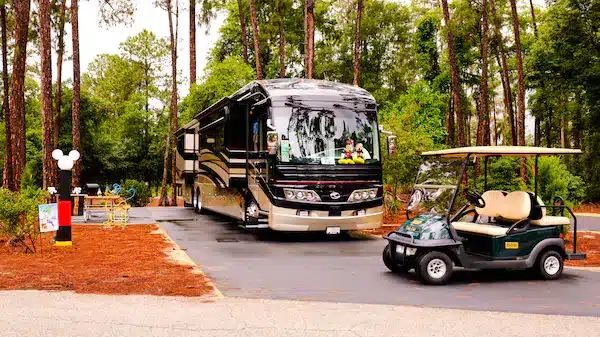 Campsites at Fort Wilderness Campground with RV setup and shaded wooded surroundings
