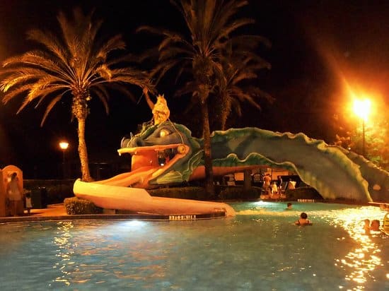 Disney’s Port Orleans French Quarter pool featuring Doubloon Lagoon with a whimsical sea serpent water slide, Mardi Gras theming, colorful aquatic play area, and lush tropical surroundings at Walt Disney World Resort