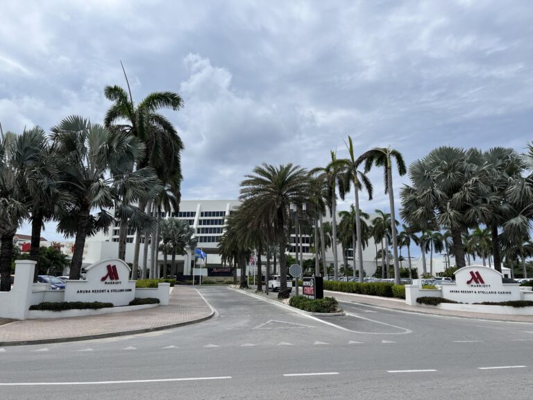Exterior of Aruba Marriott Resort & Stellaris Casino with palm trees along Palm Beach