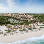 Aerial view of ATELIER Playa Mujeres with the beachfront resort, pools and white-sand beach in Mexico