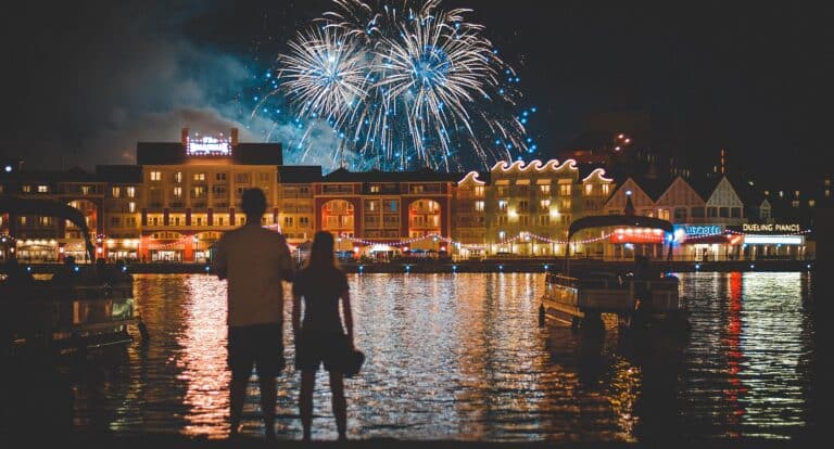 Disney's BoardWalk Resort illuminated at night with fireworks over Crescent Lake