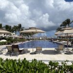 Main pool at Dreams Tulum Resort & Spa with loungers, palm trees and the Caribbean beach beyond