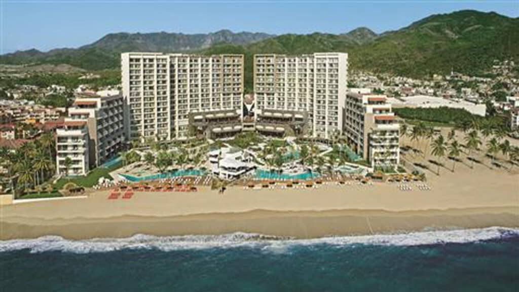 Aerial view of Dreams Vallarta Bay Resort & Spa with the beachfront tower, pools and Pacific shoreline in Puerto Vallarta, Mexico