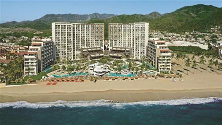 Aerial view of Dreams Vallarta Bay Resort & Spa with the beachfront tower, pools and Pacific shoreline in Puerto Vallarta, Mexico