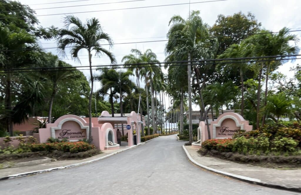 Palm-lined entrance driveway and pink Fairmont Royal Pavilion signs in Barbados