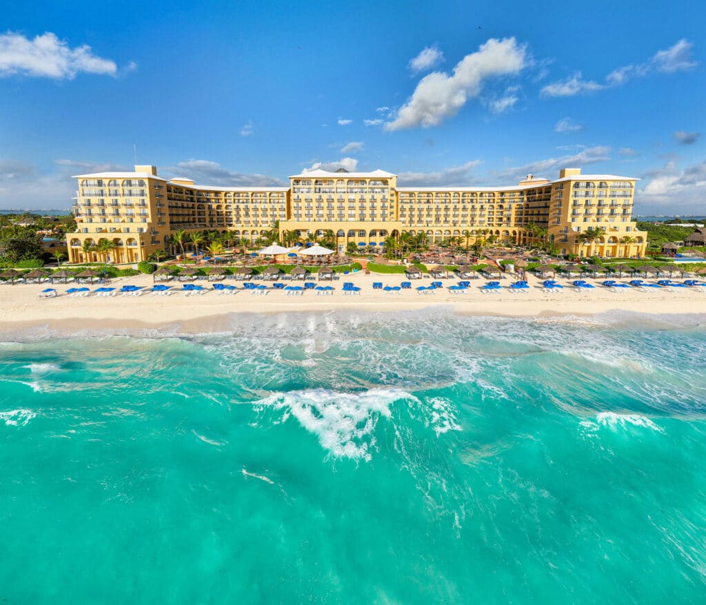 Beachfront exterior of Kempinski Hotel Cancún, the former Ritz-Carlton Cancun property, beside turquoise Caribbean water