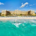 Beachfront exterior of Kempinski Hotel Cancún, the former Ritz-Carlton Cancun property, beside turquoise Caribbean water