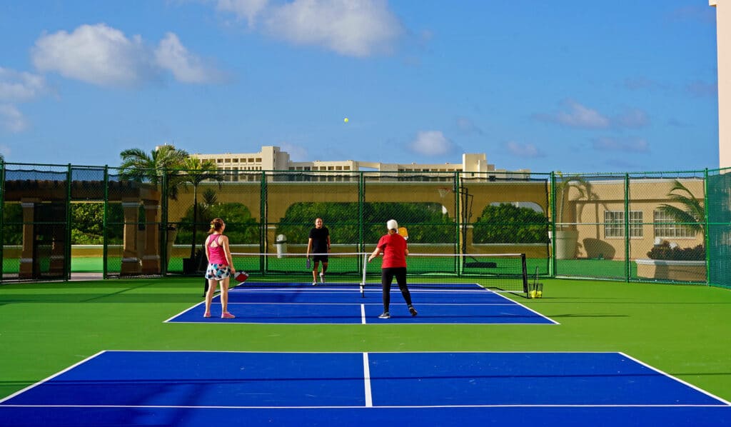 Pickleball courts with the beachfront resort behind at Kempinski Hotel Cancún, formerly The Ritz-Carlton Cancun