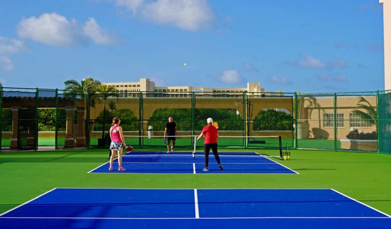 Pickleball courts with the beachfront resort behind at Kempinski Hotel Cancún, formerly The Ritz-Carlton Cancun