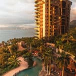 Garza Blanca Puerto Vallarta resort tower and tropical pool overlooking Banderas Bay at golden hour