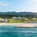 Aerial view of Half Moon Jamaica resort buildings along a sheltered turquoise beach in Montego Bay