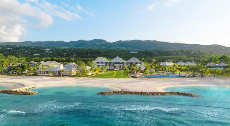 Aerial view of Half Moon Jamaica resort buildings along a sheltered turquoise beach in Montego Bay