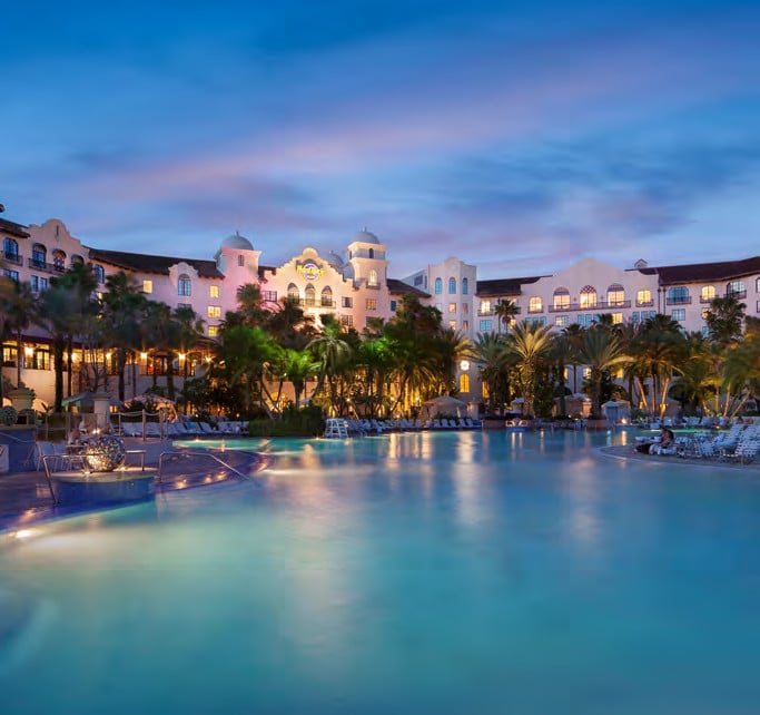 Large resort pool and illuminated Hard Rock Hotel at Universal Orlando at twilight