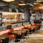 The Kitchen restaurant interior at Hard Rock Hotel at Universal Orlando with orange booths and rock music decor