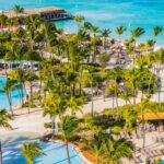 Elevated view of the pools, palm trees and turquoise beachfront at Hilton Aruba Caribbean Resort