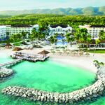 Aerial view of Hyatt Ziva Rose Hall with resort buildings, pools and turquoise beachfront in Montego Bay Jamaica