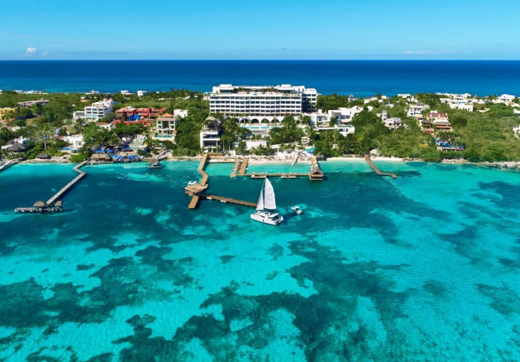 Aerial view of Impression Isla Mujeres by Secrets above turquoise Caribbean water and the resort pier