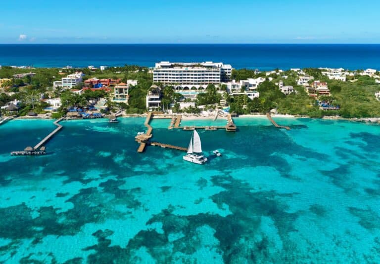 Aerial view of Impression Isla Mujeres by Secrets above turquoise Caribbean water and the resort pier