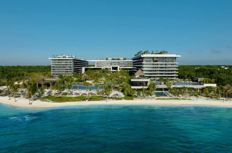 Aerial view of Impression Moxché by Secrets with beachfront resort buildings and pools in Playa del Carmen