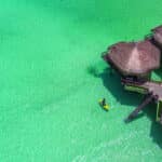 Aerial view of Palafitos Overwater Bungalows above turquoise water at El Dorado Maroma in Riviera Maya