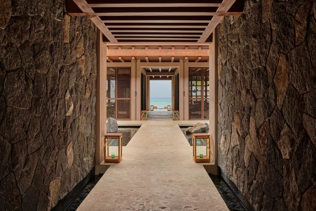 Stone open-air corridor framing water and tropical scenery at Rosewood Mayakoba in Riviera Maya