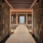 Stone open-air corridor framing water and tropical scenery at Rosewood Mayakoba in Riviera Maya