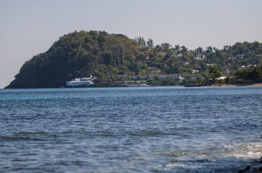 Round Hill Hotel and Villas spread across a green Jamaican hillside above the blue Caribbean Sea