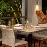 Elegant restaurant table setting at Sandals Grande St. Lucian surrounded by tropical greenery