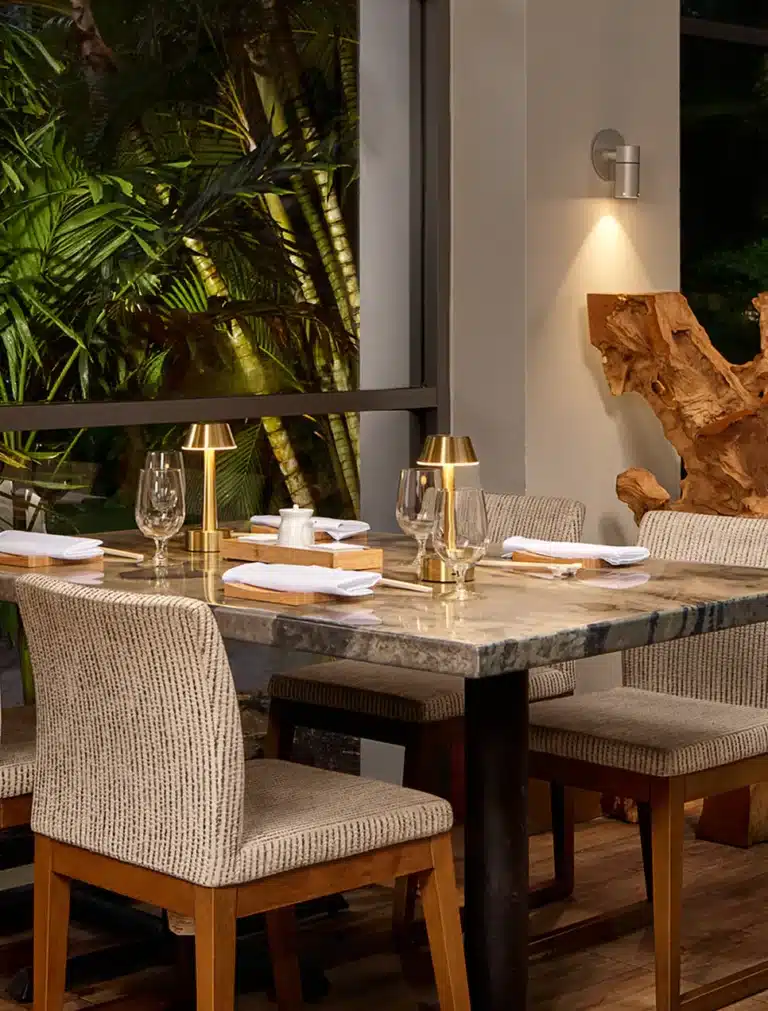 Elegant restaurant table setting at Sandals Grande St. Lucian surrounded by tropical greenery