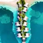 Aerial view of overwater bungalows surrounded by turquoise Caribbean water at Sandals Grande St. Lucian