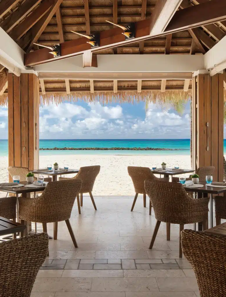 Open-air beachfront restaurant dining at Sandals Royal Barbados overlooking the Caribbean Sea
